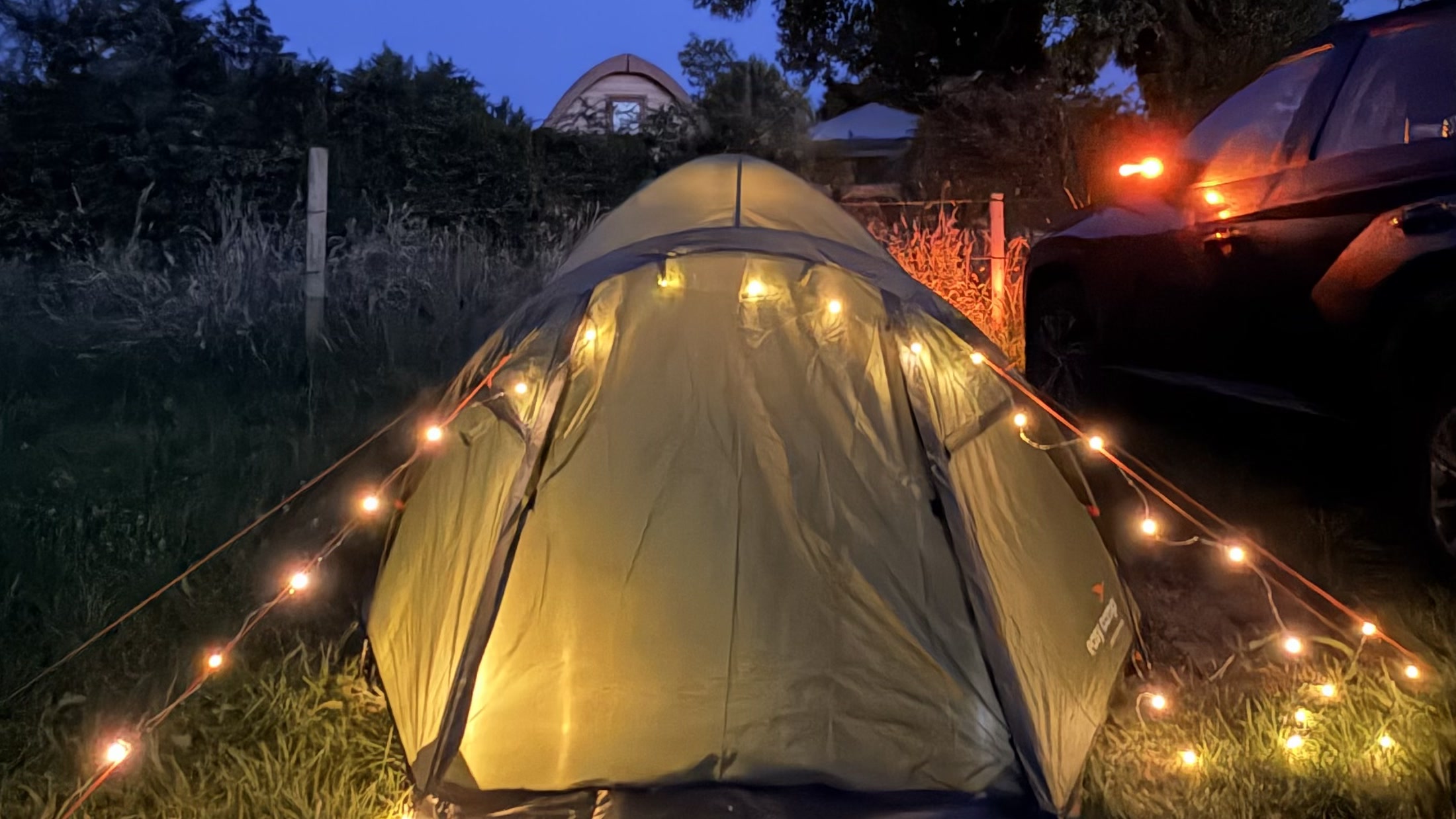 A tent glowing with warm fairy lights at the West Cork campsite after dark